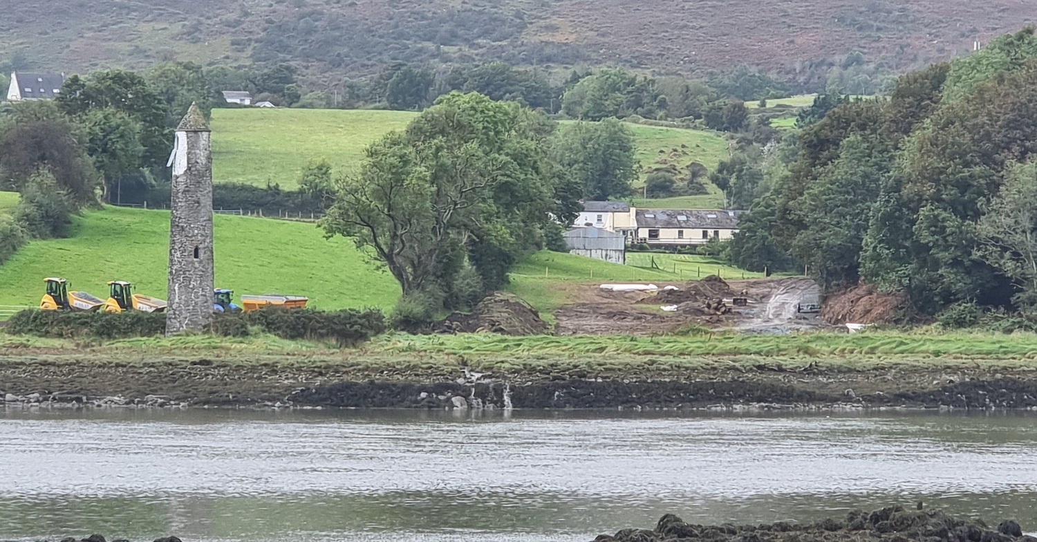 Water in foreground, round tower to left
                          with various pieces of machinery sitting to
                          its right.