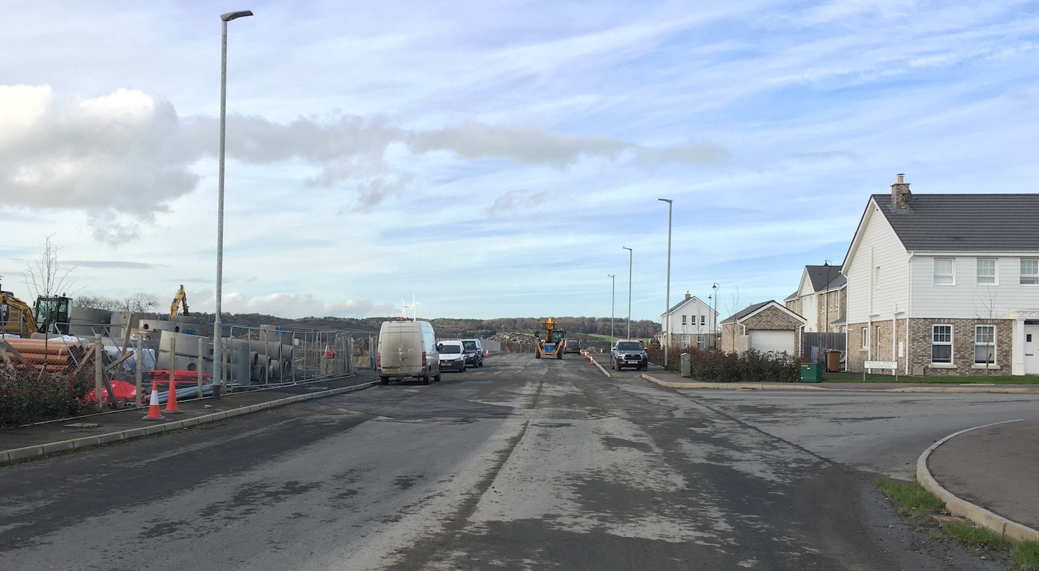 Road ending abruptly at a building site,
                          with open ground to the left and a new house
                          on the right.