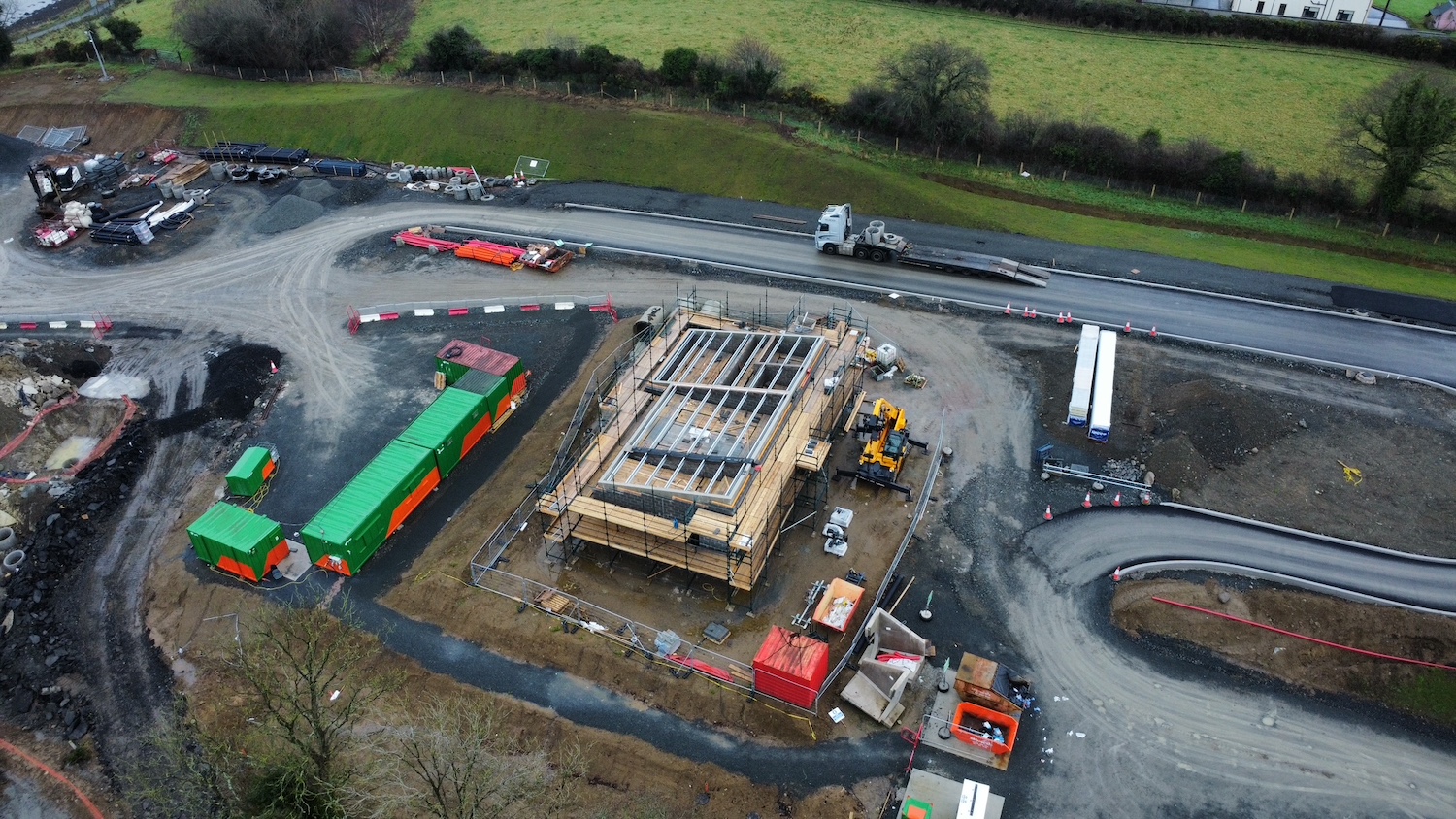 Building under construction seen from
                          above with work completed up to the rafter
                          level.