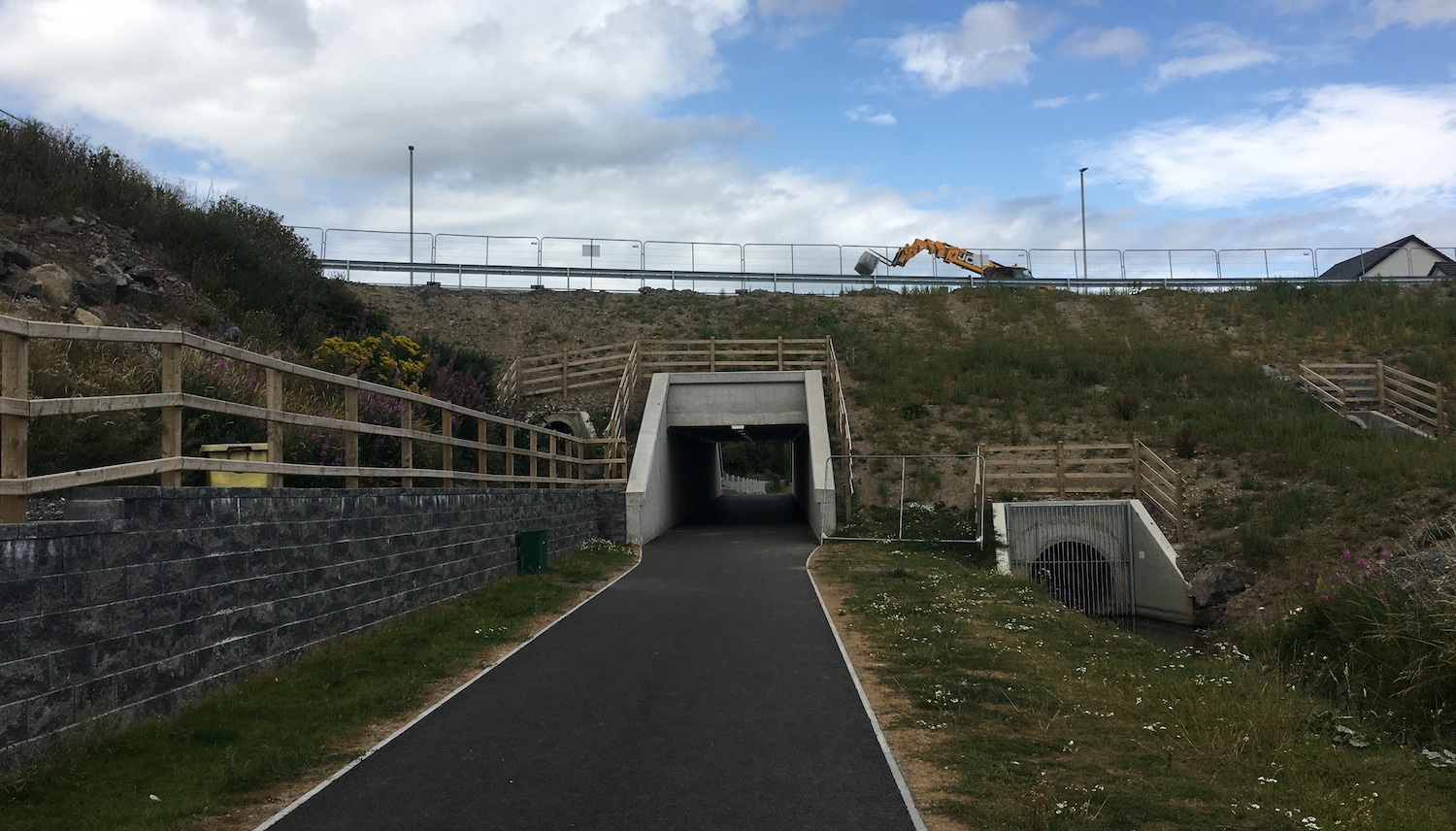 View along a culvert under a large
                          embankment which runs left-right. A stream
                          runs through a second culvert on the right,
                          while a smaller third culvert is on the left.